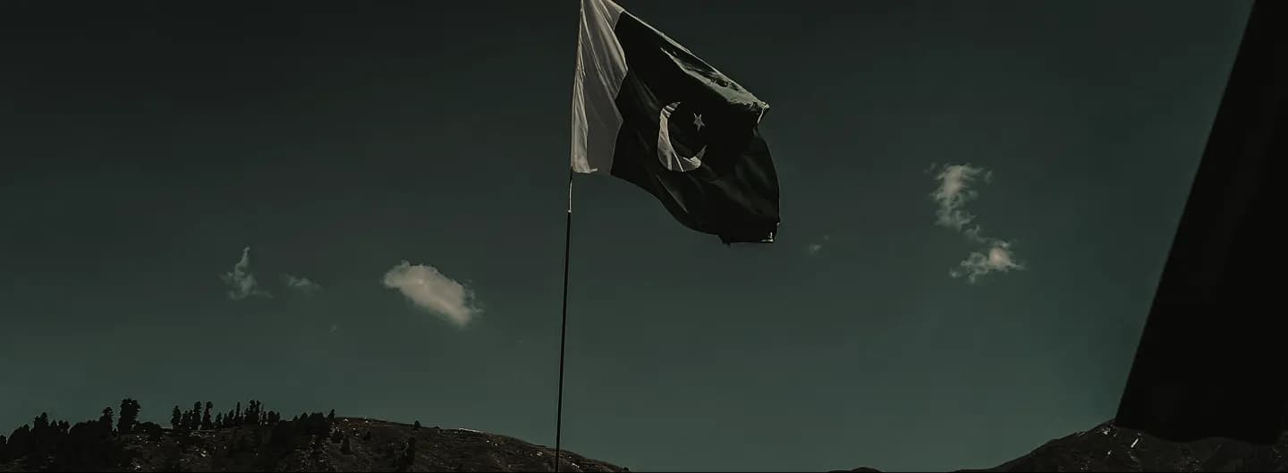 Pakistani flag over a mountain ridge
